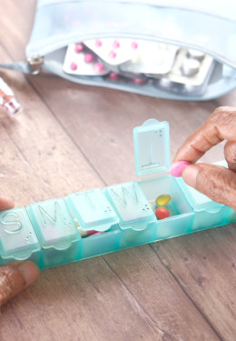 senior women hands taking medicine from a pill box