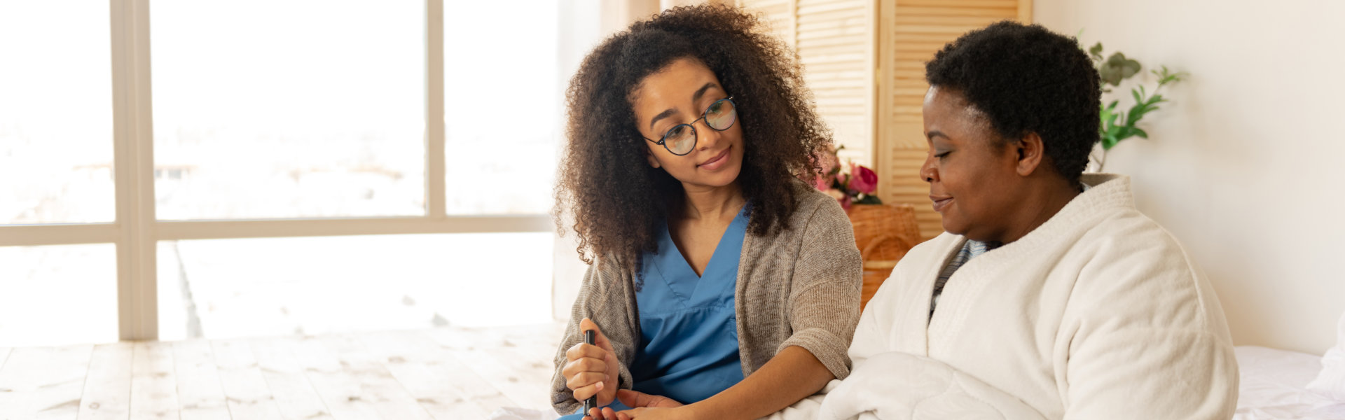 Nurse wearing glasses taking blood test for woman with diabetes